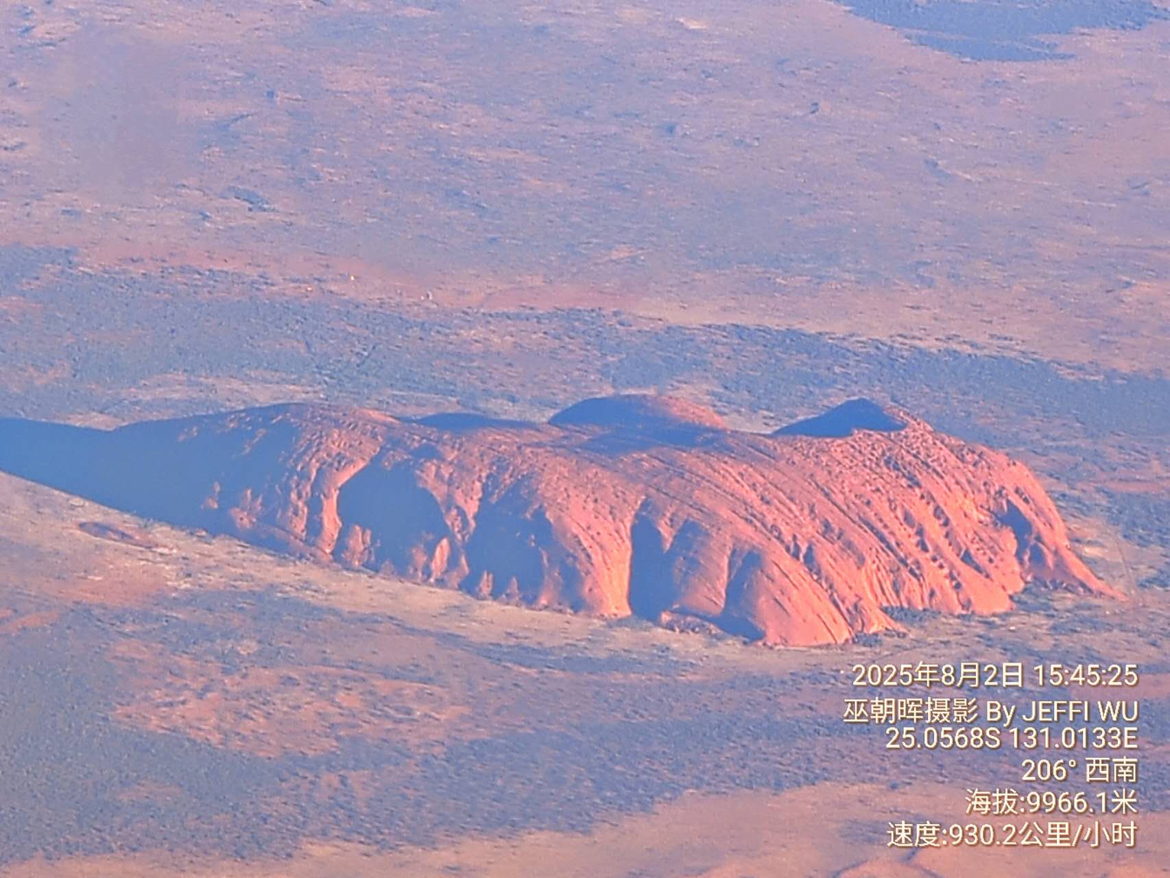 2 August 2025. The author photographed Uluru from an altitude of approximately 9,966 metres while flying over central Australia. The image records the overall landform structure of Uluru and its surrounding desert landscape from an aerial perspective.